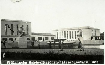 SW-Foto ›Pfälzische Handwerksschau Kaiserslautern 1925‹. Hintergrund: moderne weiße Gebäude im Bauhaus-Stil. Mitte: ein Wasserbassin, gerahmt von zwei weißen Rossbändiger-Figuren. Um das Bassin: viele Besucher.