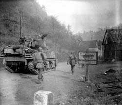 Bild von amerikanischem Panzer und zwei Soldaten auf dem Weg in ein pfälzisches Dorf.