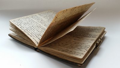 Aufgeschlagenes handschriftlich beschriebenes, älteres Tagebuch.